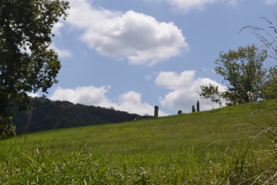 A grassy hill with gravestones