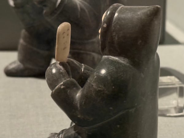 The same carved statue as the image at the beginning of the newsletter, in side profile. This angle reveals that on side of the mirror facing the seated figure there are two arches for eyebrows, two dots for eyes, to dots for nostrils, and a straight line for the mouth.