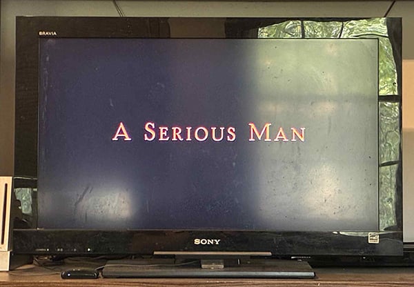 A television with a blank screen and the words A Serious Man in white letters