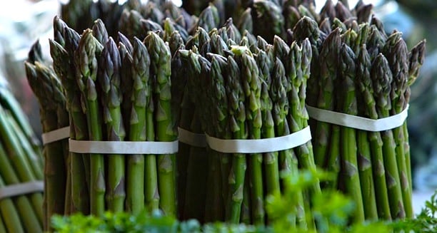 Photo of several bunches of spring asparagus at the farmers' market.