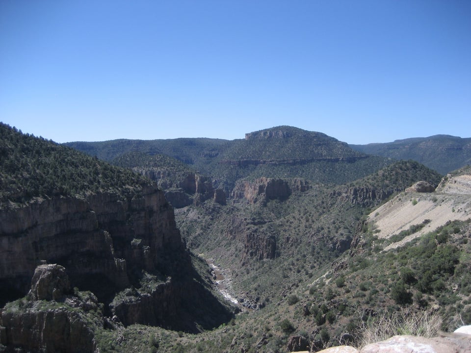 A steep canyon, the sides and tops covered in small shrubs.