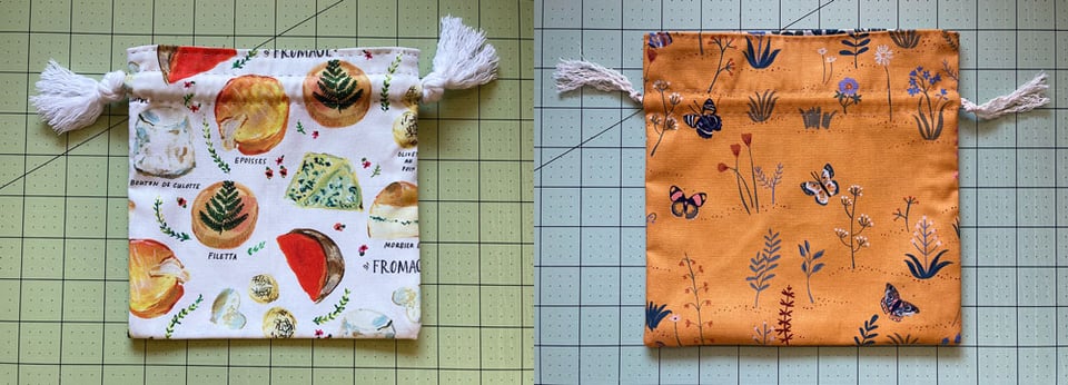 Two small drawstring bags: one is made with fabrics showing prints of varying kinds of cheeses on a white background; the other is golden hued with various desert plants and butterflies scattered around.
