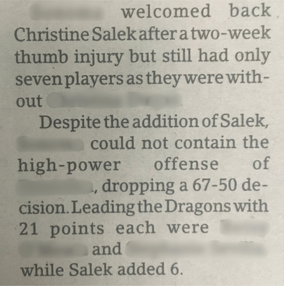 Scan of a newspaper article with blurred out names and locations. Redacted city name welcomed back Christine Salek after a two-week thumb injury but still had only seven players as they were without redacted name. Despite the addition of Salek, redacted city name could not contain the high-power offense of redacted opponent name, dropping a 67-50 decision. Leading the Dragons with 21 points each were redacted teammate and redacted teammate, while Salek added 6.