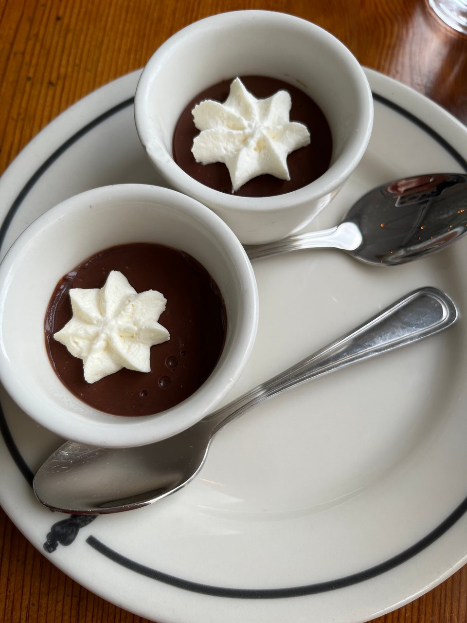 2 cups of chocolate pudding with piped whipped cream stars on saucers with spoons at the Mermaid Inn, New York City