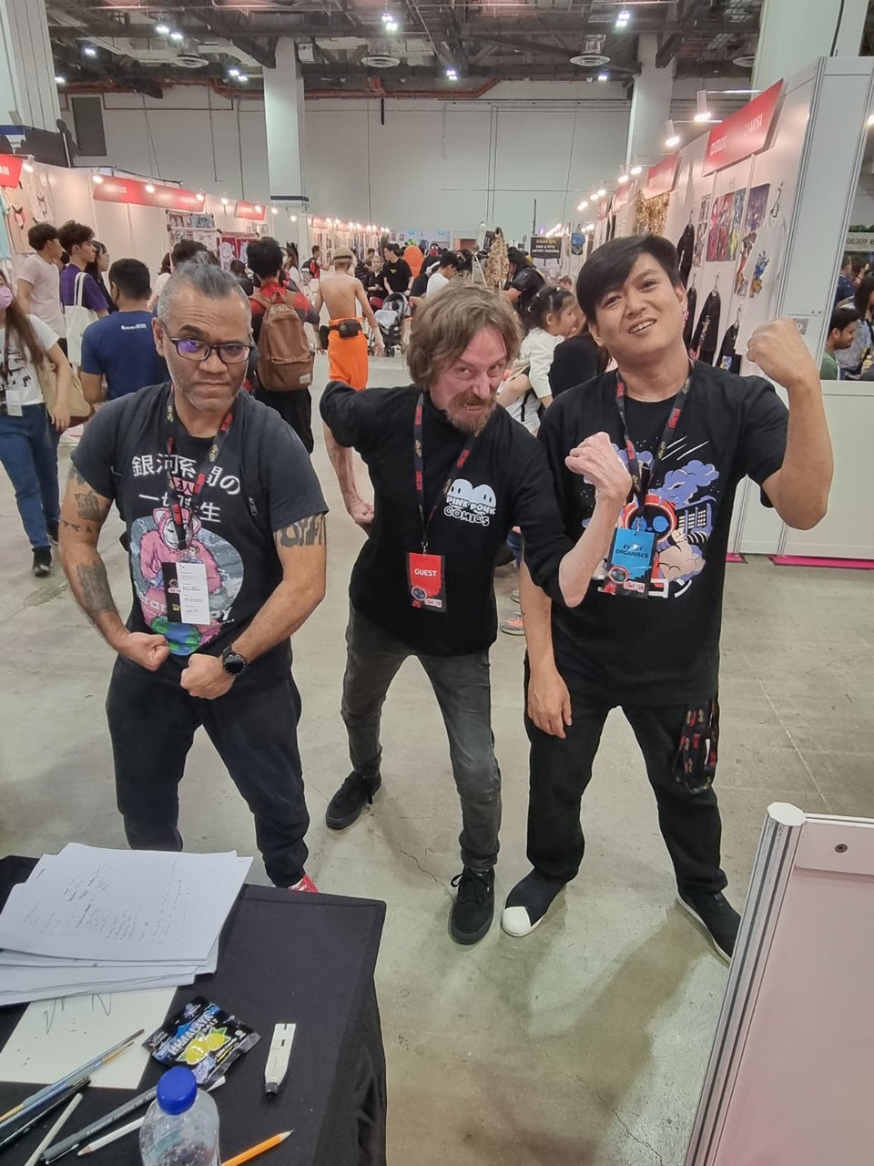 A photo of myself, Glenn Fabry, and my friend, Paul, all flexing in front of a crowd at Singapore Comic Con.