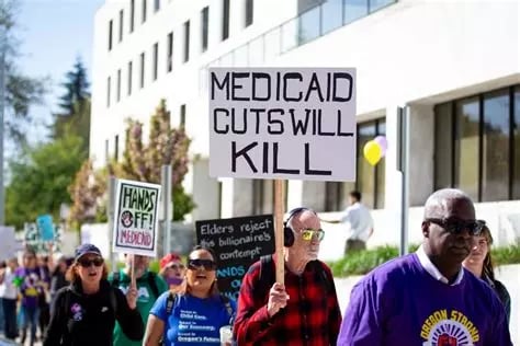 People protesting proposed cuts to Medicaid. One holds a sign saying "Medicaid Cuts Will Kill"