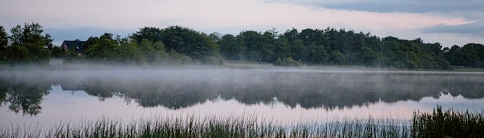 a lake with mist in the morning