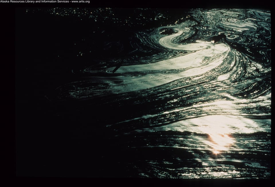 A dark, slick pool of oil reflects light