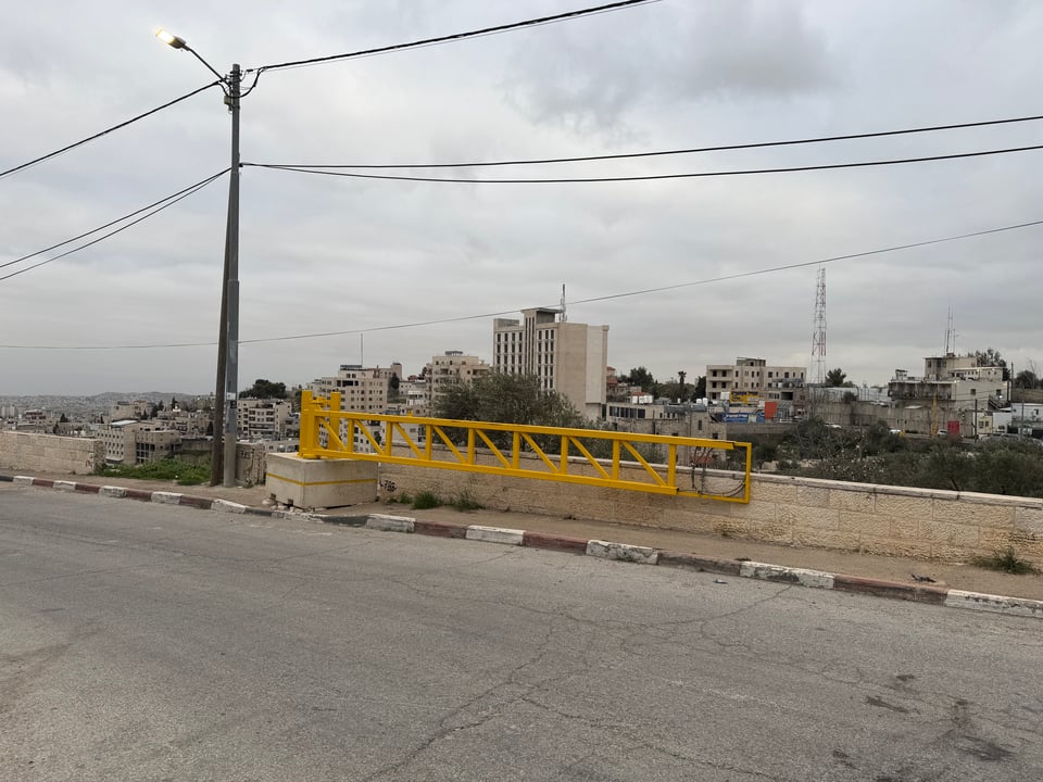 A road with a yellow metal barrier
