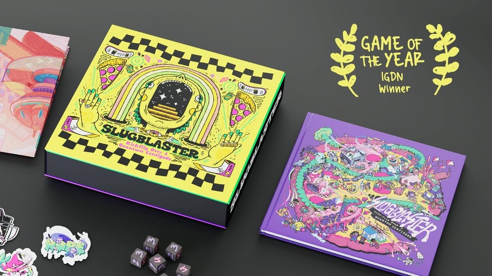 A yellow box, similar to a pizza box, with audacious, graffiti-like artwork. Next to it, a purple hardbound version of Slugblaster. At the edge of the screen are black dice with purple and pink numbers on them and some stickers, one of which says NOPE.