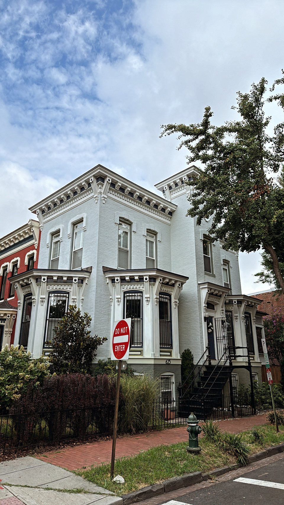 An ornate rowhouse on a street corner.