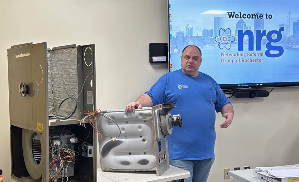 Dale stands next to a disassembled furnace to illustrate how he best helps his customers.
