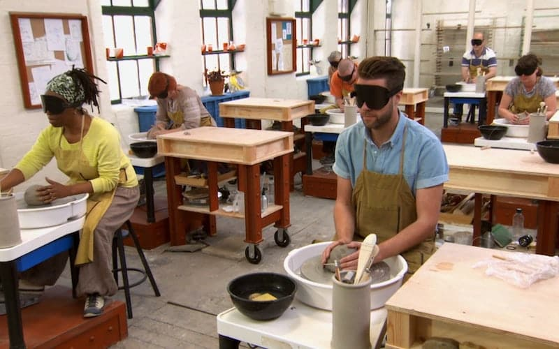 people working in a pottery studio