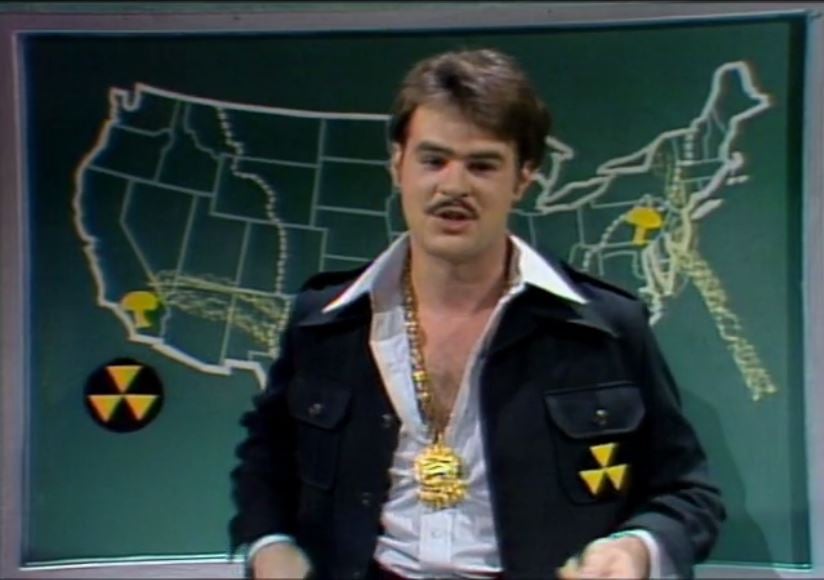 a man in a jacket standing in front of a map