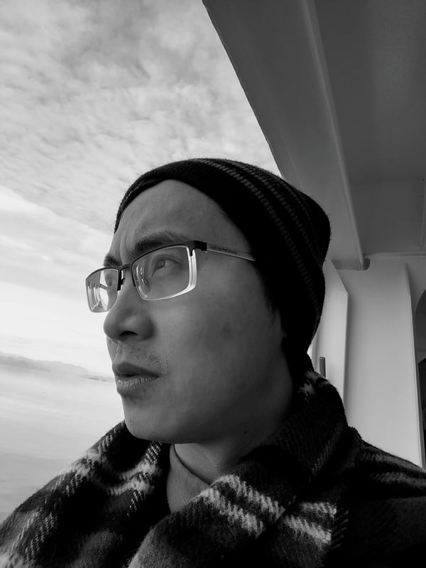 Author Isaac Yuen with sea and sky behind him
