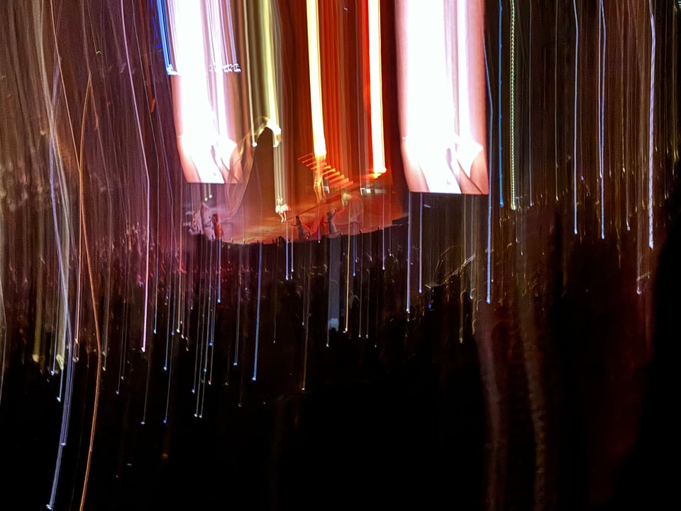 a view of the stage from ROSALÌA at the Kia Forum in Los Angeles. In the image there are numerous light beams that look like they're being generated up from the audience.