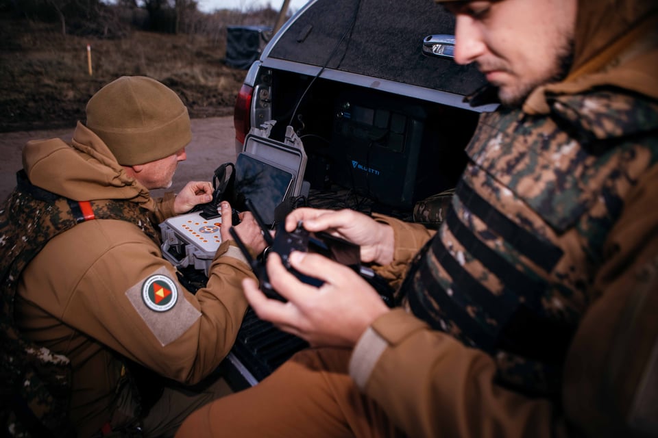 Two uniformed Ukrainians operate drones