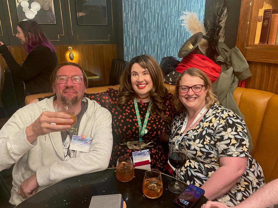 Three people, one of whom (me) resembles a tomato, in the bar at Eastercon