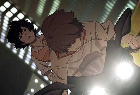 A screenshot from Zankyou no Terror showing a teen girl on the back of a motorbike being driven by a brown-haired teen boy. Headlights flash brightly a the screen and lit-up office buildings fill the background