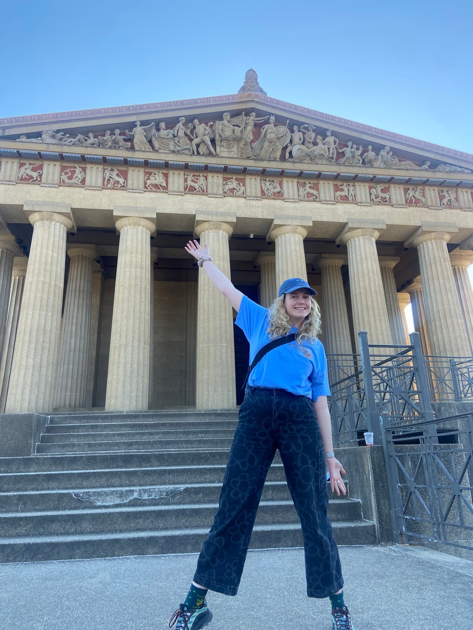 a woman standing in front of the parthenon in nashville