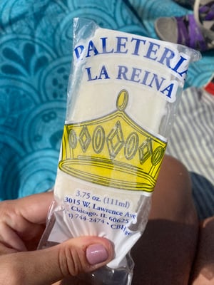 Lucianne's hand holds a piña colada paleta from Paleteria La Reina in Chicago