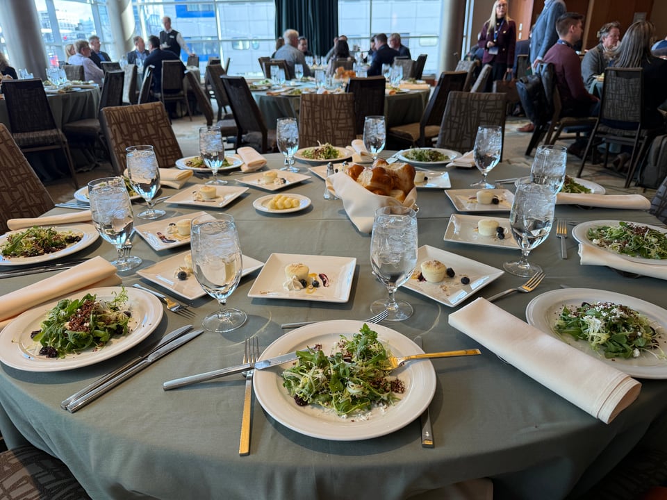 photo of a table in a banquet hall with 10 place settings for lunch, but no one seated at the table