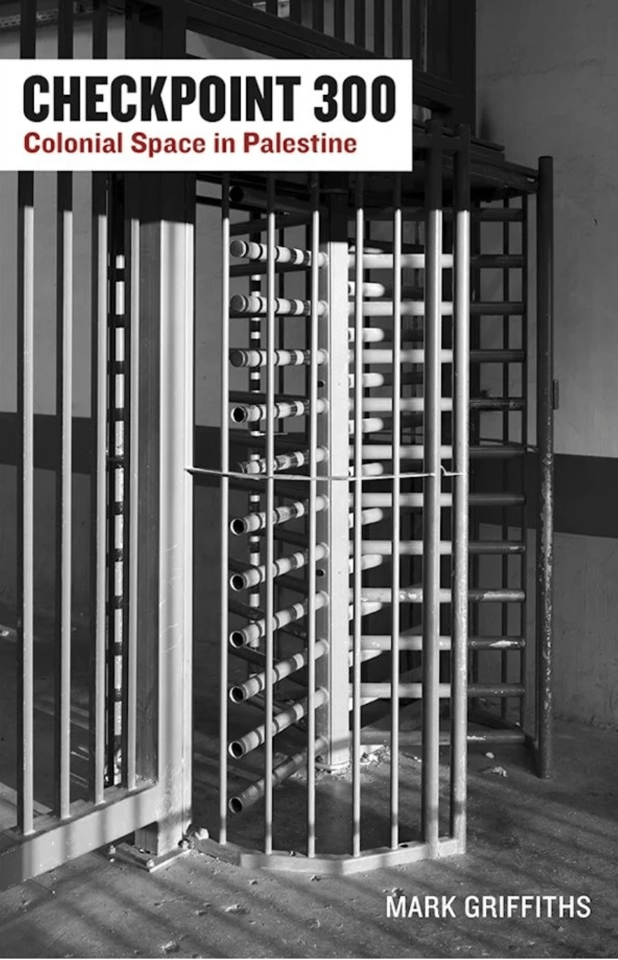 Photograph of book called Checkpoint 300: Colonial Space in Palestine by Mark Griffiths. The full cover is a black and white image of a large and imposing  metal turnstile and gate with bars