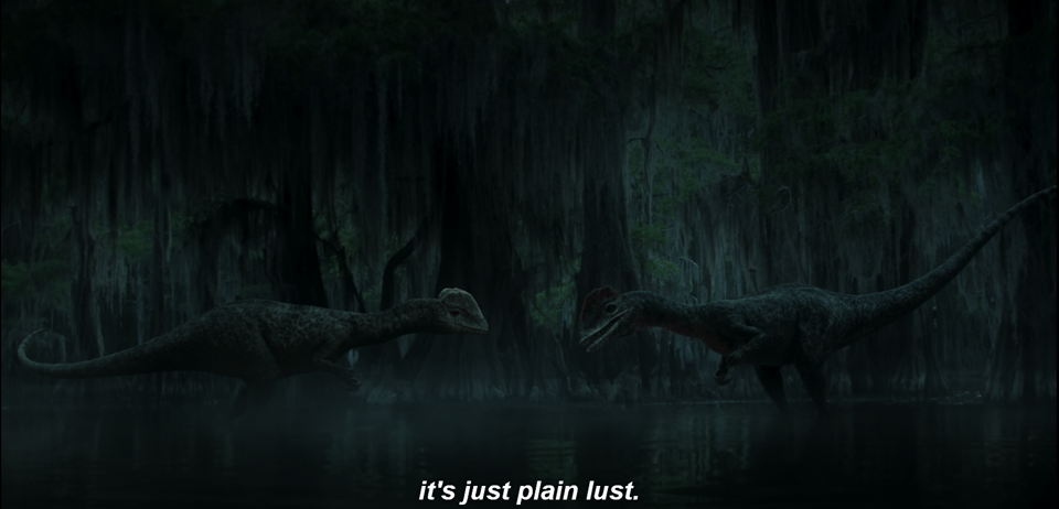 A very dark screengrab showing two Dilophosaurus facing each other in the swamp. The one on the left is supposed to be female, the one on the right male, showing captioning from the narration "but it's not bloodlust, it's just plain lust."