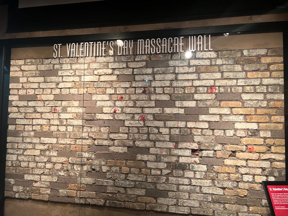 Photograph of the current display of the wall at The Mob Museum. It says St Valentine's Day Massacre Wall at the top of the display.