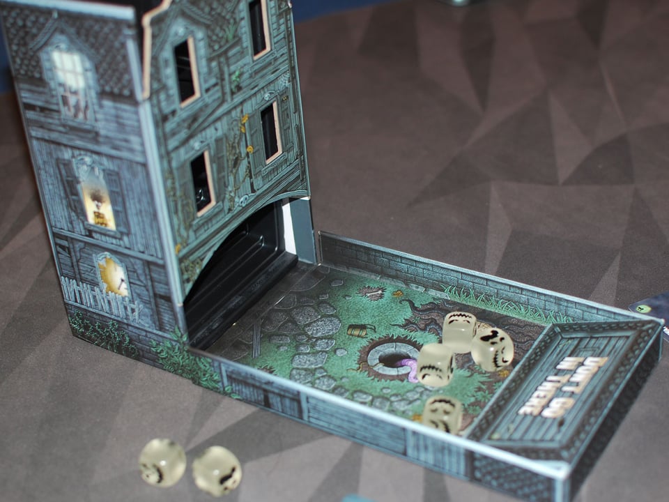 A spooky dice tower with transparent ghost dice in it