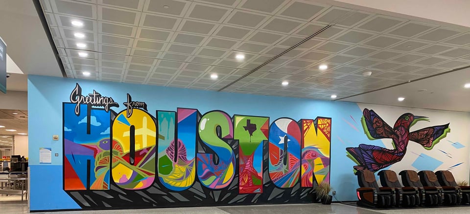 colorful mural that says "greetings from Houston"