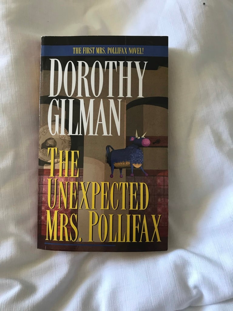 A book on a bedsheet. The book's titel is The Unexpected Mrs Pollifax
