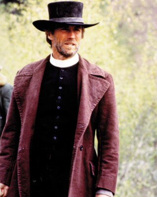 Father Carmody, a preacher in the wild west, wears a white collar, a long coat and a cowboy hat