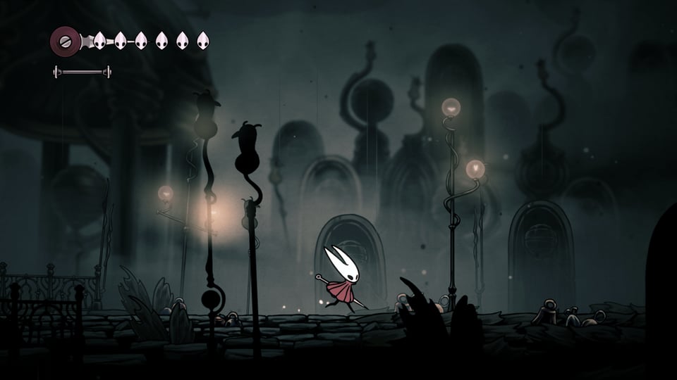 Hornet, a bug-like character with two spiny protrusions on its white head, with two hollow black ovals for eyes, wields a large needle and wears a red dress-like outfit. She runs through a dark landscape of strange buildings and tall lanterns, some of which have gone dark. The structures resemble gravestones, and the whole scene is drawn in shades of grey, with faint yellow light being the only points of color.