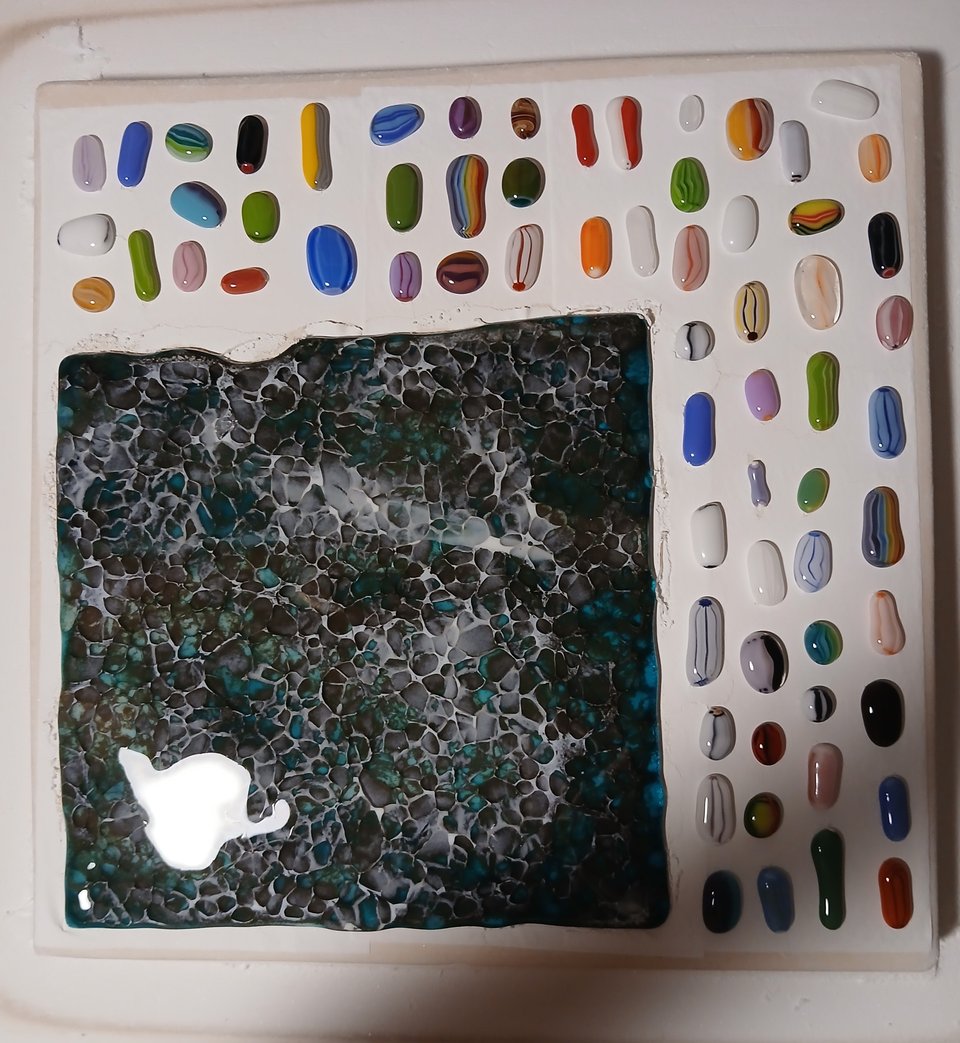 the murrine has melted into long cabochons. the sheet has reacted to the white, giving it a mottled blue and brown appearance with the dragon scale texture