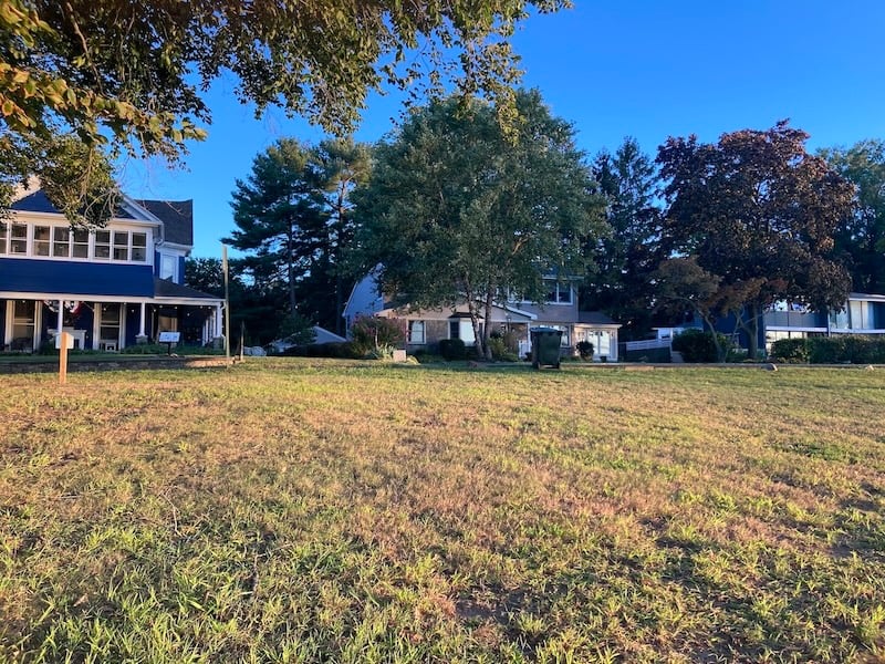 Photo of two houses with grass in foreground