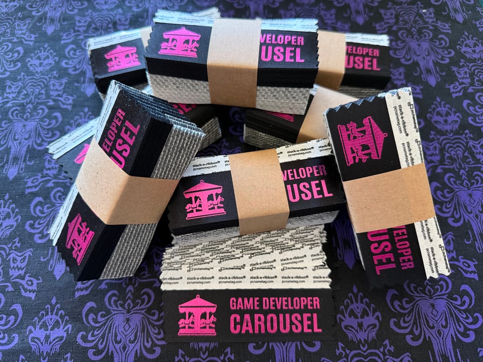 A collection of bundled badge ribbons. Each ribbon has a black background with "Game Developer Carousel" and the logo in pink.
