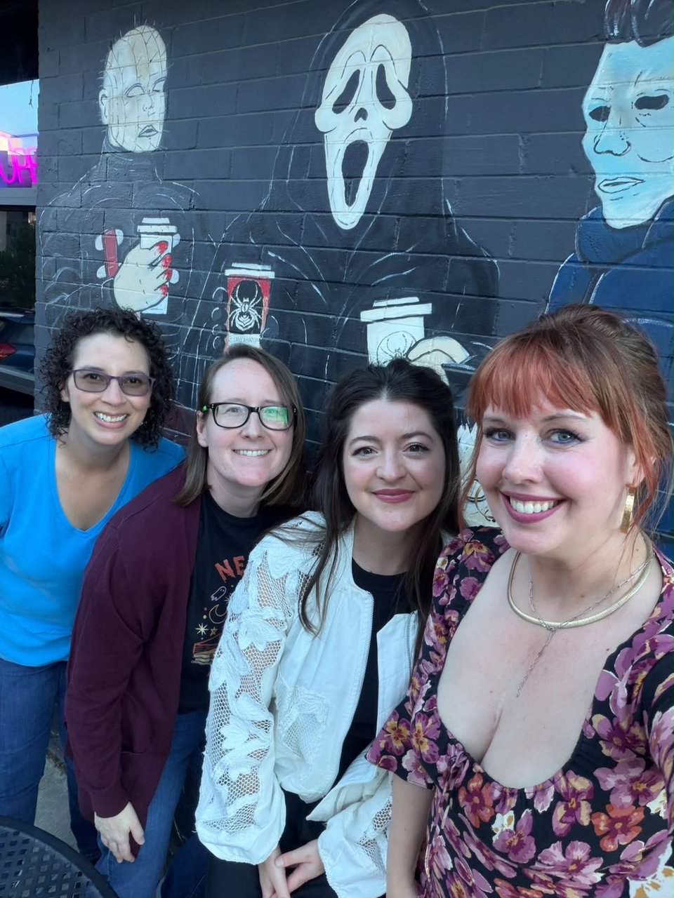 Fabulous 2027 debut authors outside of coffeeshop Scr3am & Sugar!
From left to right: Amanda Helms in a blue shirt; Mel Lake in a maroon jacket over a black shirt; Celia Lake in a white blouse over a black shirt; Debbie Gale Mitchell in a flower-patterned dress