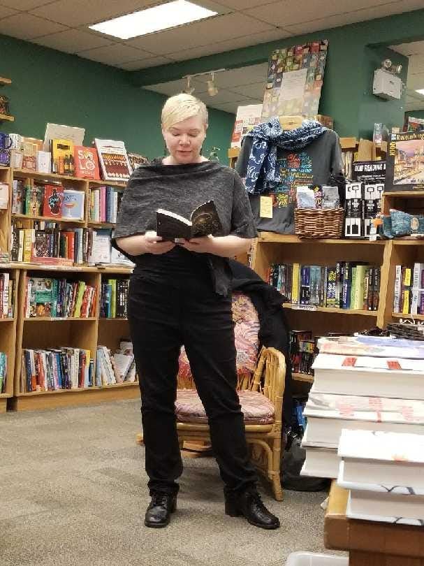 Kate in a grey shawl reading from Alice Payne Arrives.