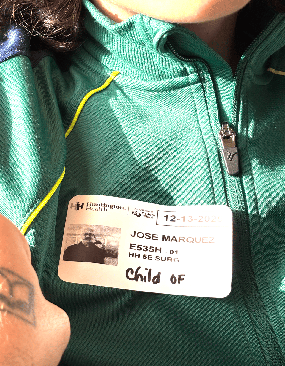 a photo of my son's jacket while he wears a paper ID from a hospital