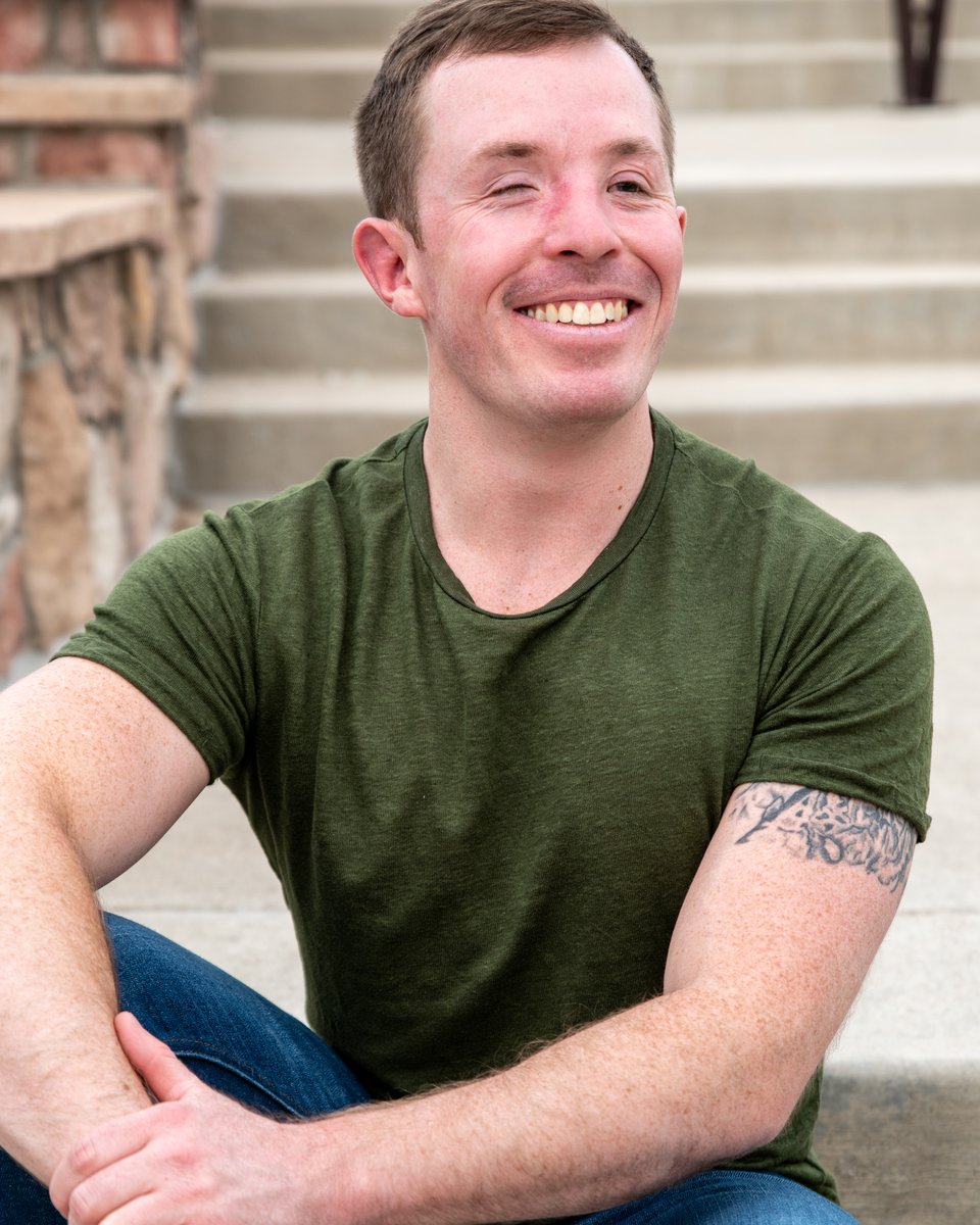 Zach sitting on cement steps in a green shirt with a relaxed smile