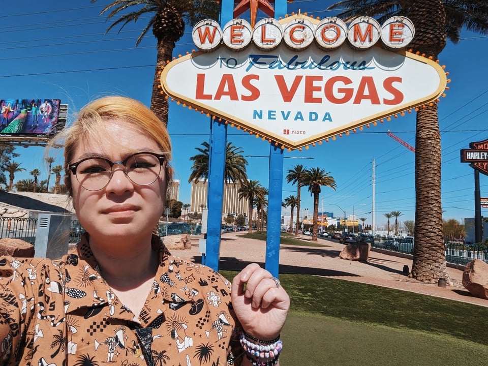 A selfie of Jen in front of the Welcome to Fabulous Las Vegas sign.