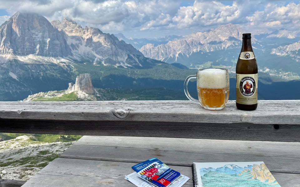 painting and beer in the foreground in front of mountains
