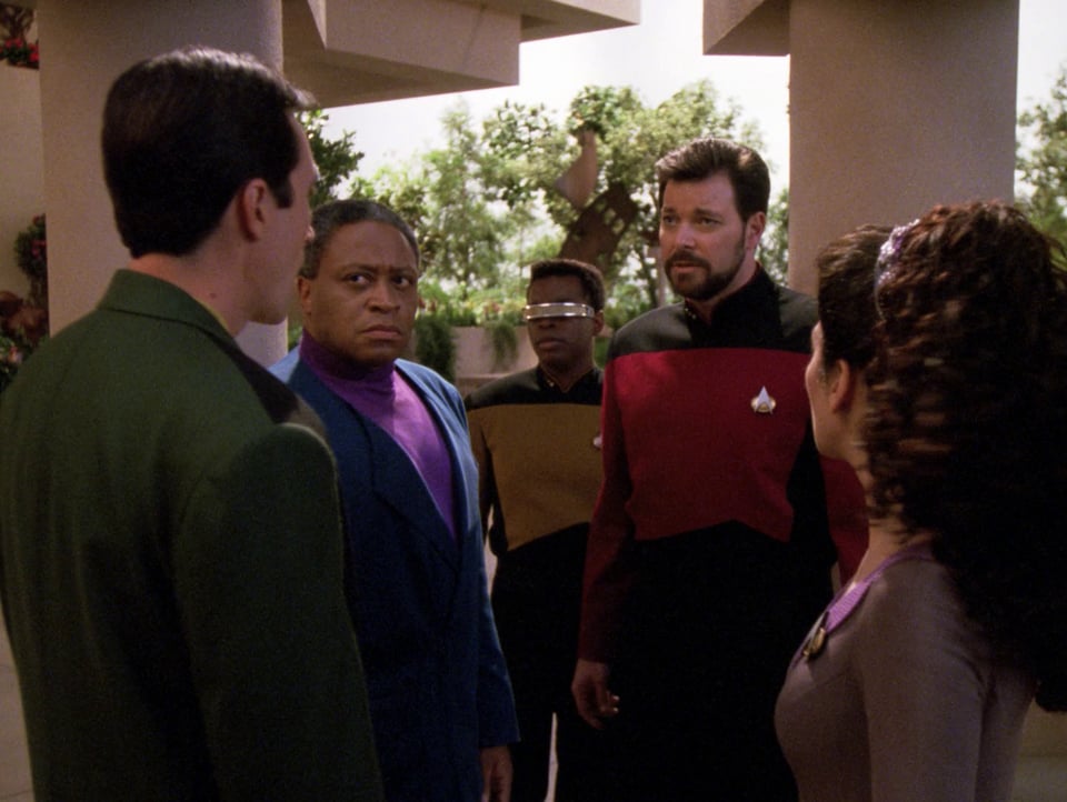 Riker, Troi, and LaForge are on an away mission, speaking to two representatives of the planet's human society.