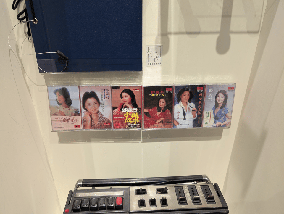Six cassetes of Teresa Teng propped up in a museum display.