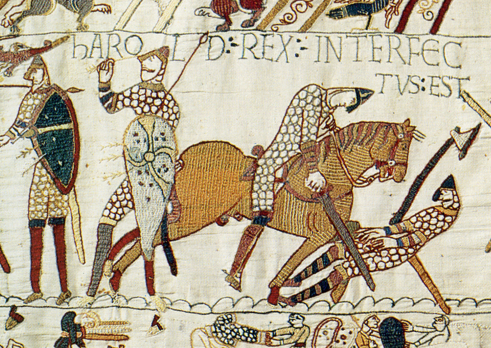 The Latin text says "Harold Rex interfectus est" although some scholars believe it said something different before restoration. It shows a dude ostensibly getting an arrow in the eye, another dude not doing well on a horse (maybe he's bent over to try to hack at the man on the ground, but I really feel like he's been wounded himself) and a man on the ground, who is most likely Harold, being chopped at.