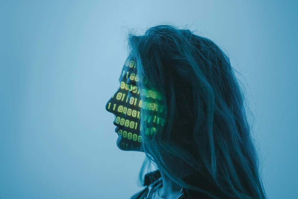 Stock photo of a woman with binary code projected onto her face