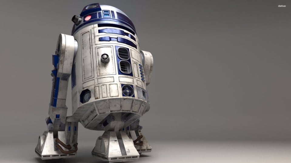 A detailed 3D rendering of R2-D2 shows the iconic astromech droid standing on a smooth gray surface, its white and blue panels slightly scuffed and weathered. The lighting highlights the dome’s metallic sheen and the small red sensor light near the top. The background is plain and minimalist, drawing all focus to the robot’s familiar cylindrical form.