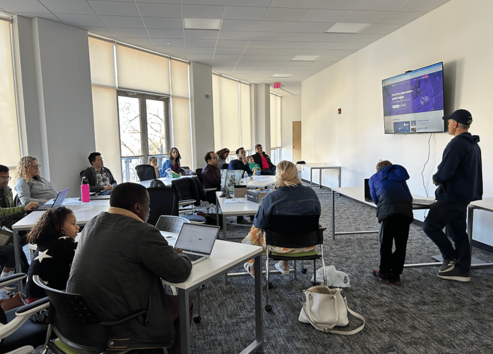 A scene from NPCC's fifth meetup on March 29, 2026, showing attendees paying attention to Nate and Leif's presentation.
