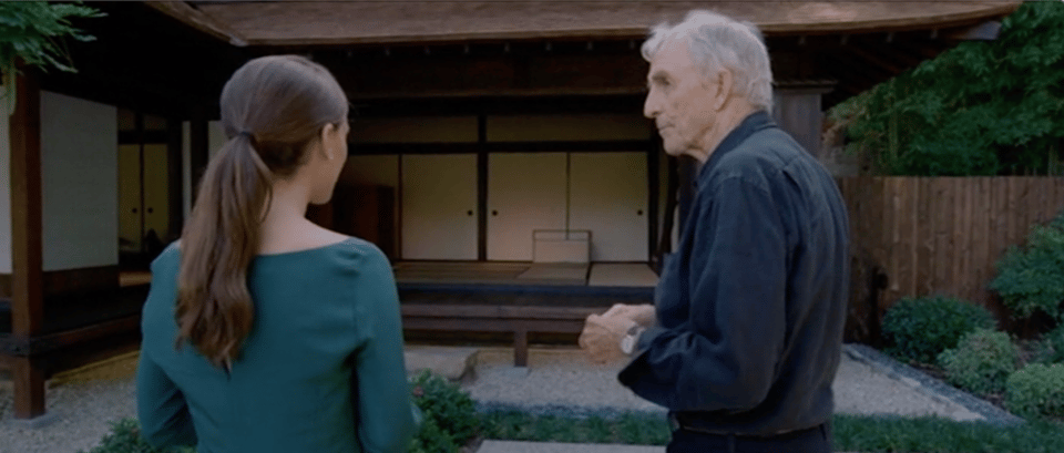 screen cap from the movie Knight of Cups, showing Natalie Portman and Peter Matthiessen talking in a zen garden